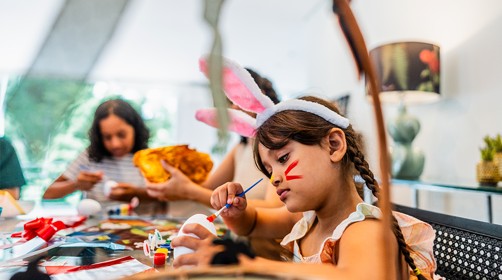 Girl decorating Easter eggs at home
